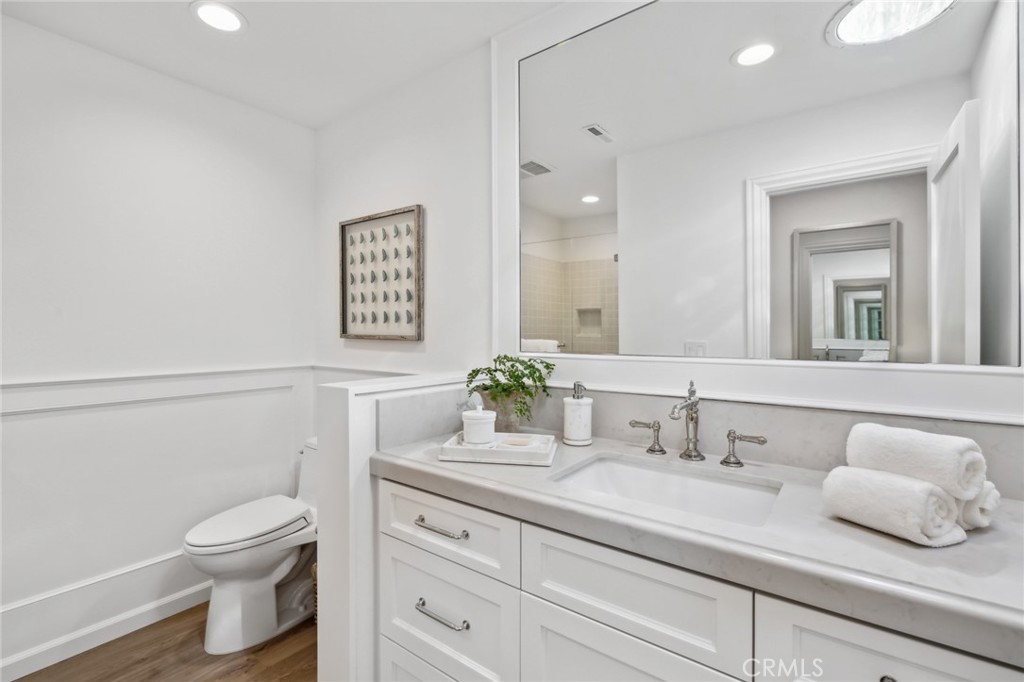 3521 Geranium Avenue, Unit 22 Corona del Mar, CA 92625 - Photo 29 of 37 a bathroom with a granite countertop toilet sink and mirror