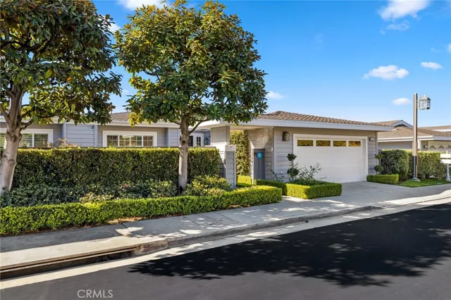 a front view of a house with a yard and potted plants