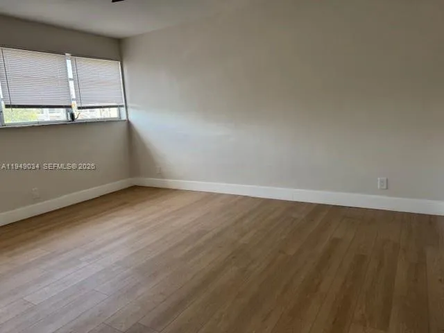 a view of a room with wooden floor and window