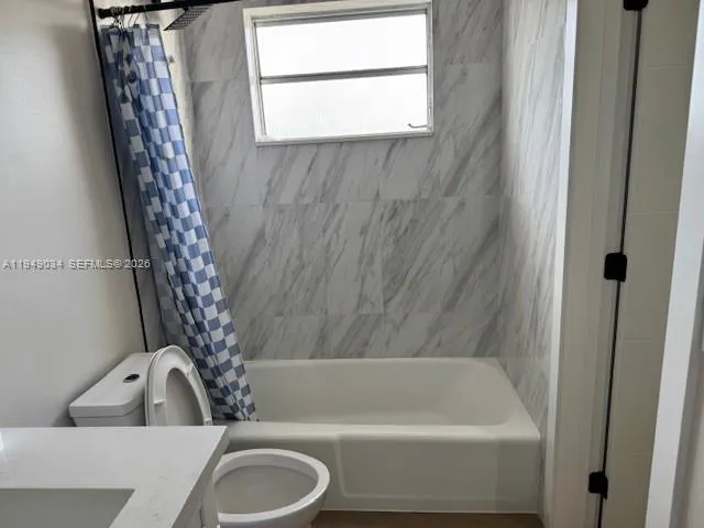 a bathroom with a tub a sink and a window
