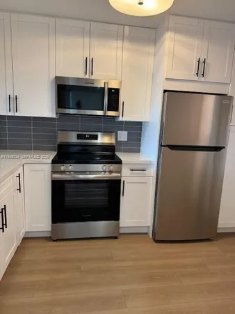 a kitchen with a refrigerator and a stove