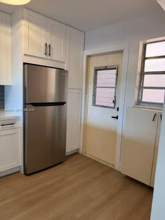 a view of kitchen with wooden floor electronic appliances and window