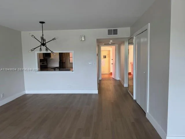 a view of a hallway with wooden floor and a ceiling fan