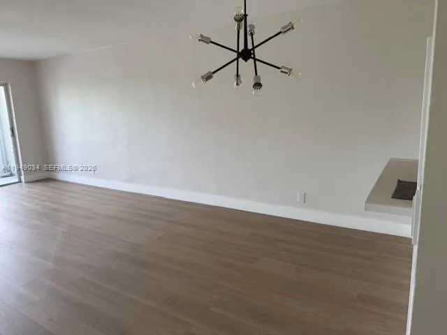 a view of a room with wooden floor and white walls