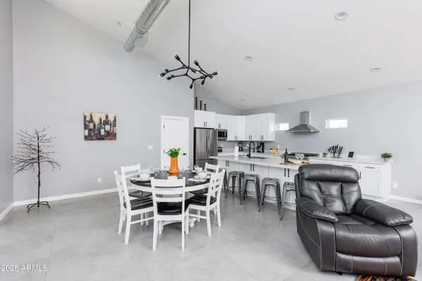 a dining room with furniture a chandelier and wooden floor