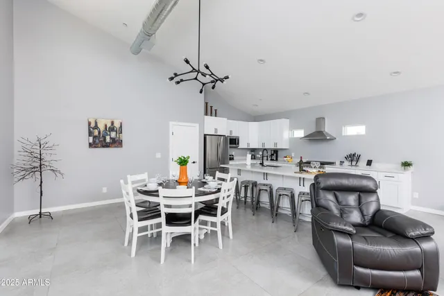 a dining room with furniture a chandelier and wooden floor
