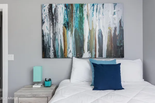 a bedroom with a bed and painting on the wall