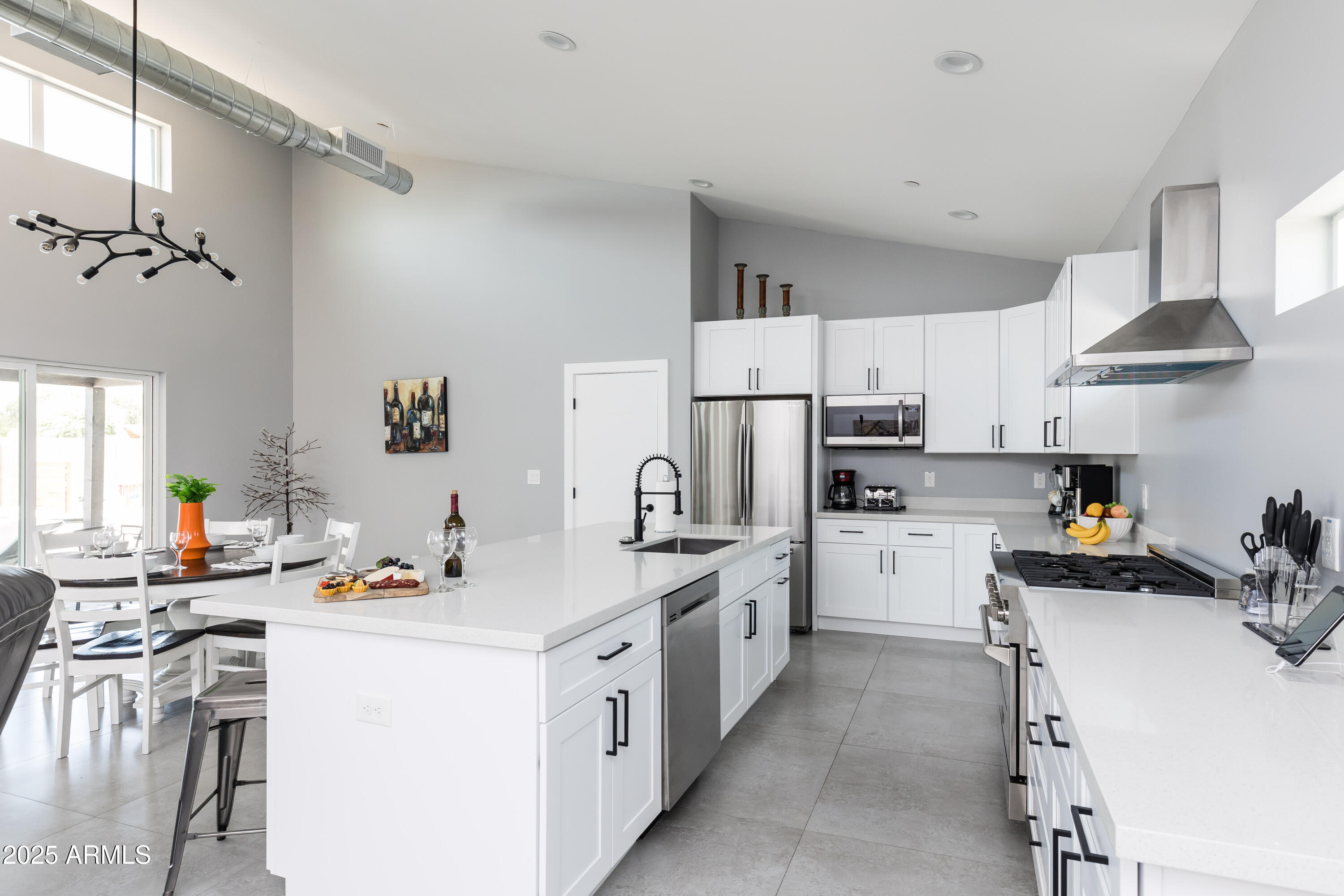 3043 North 85th Place Scottsdale, AZ 85251 - Photo 8 of 33 a kitchen with a sink stove and white cabinets
