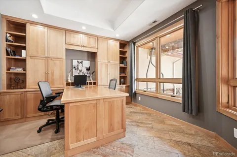 a view of a workspace with furniture and a window