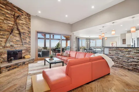 a living room with furniture a fireplace and a floor to ceiling window