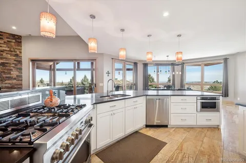 a open kitchen with stainless steel appliances granite countertop a stove and a sink