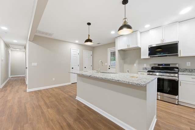 2332 Barge Road Southwest Atlanta, GA 30331 - Photo 6 of 30 a kitchen with stainless steel appliances granite countertop a sink a stove and a wooden floors
