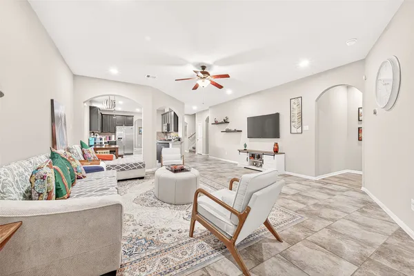 a living room with furniture a flat screen tv and a large window