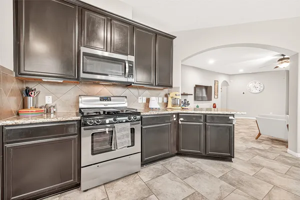 a kitchen with stainless steel appliances granite countertop a refrigerator and a stove top oven