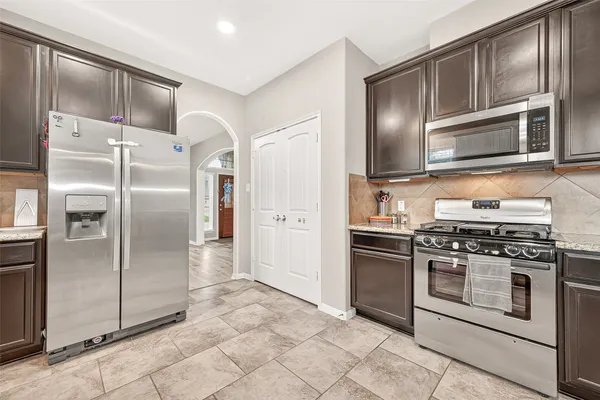 a large kitchen with kitchen island granite countertop a sink and cabinets