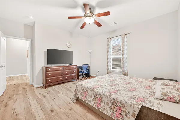 a bedroom with a large bed and a chandelier