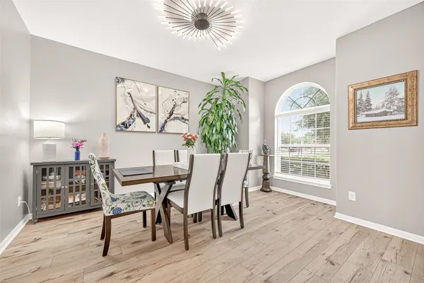 a dining room with furniture a chandelier and wooden floor