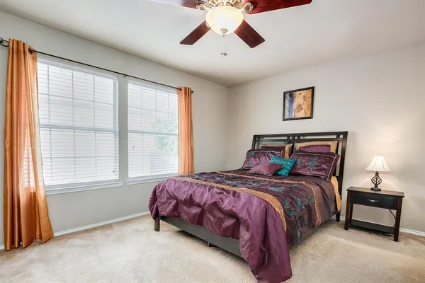 a bedroom with a bed and a large window