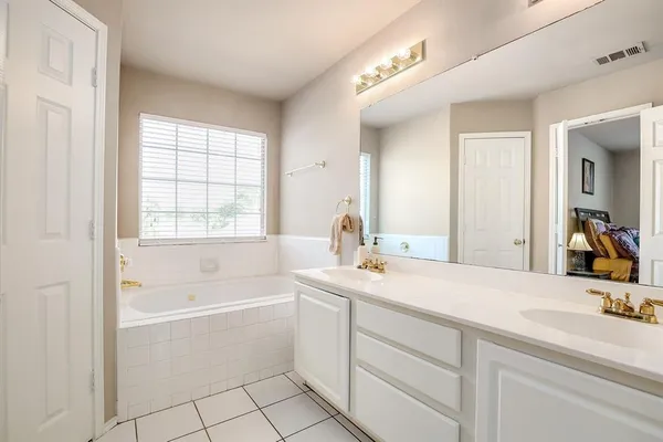 a bathroom with a tub sink and mirror