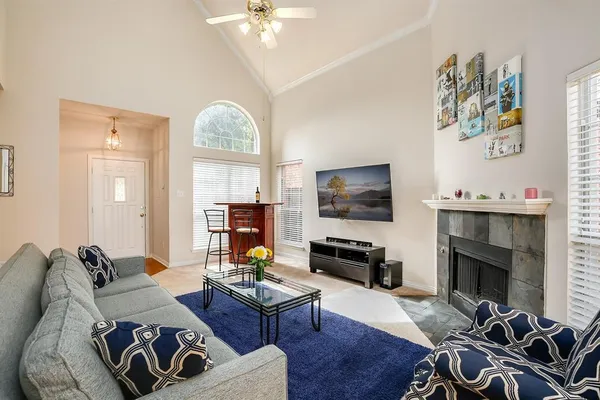 a living room with furniture a flat screen tv and a fireplace