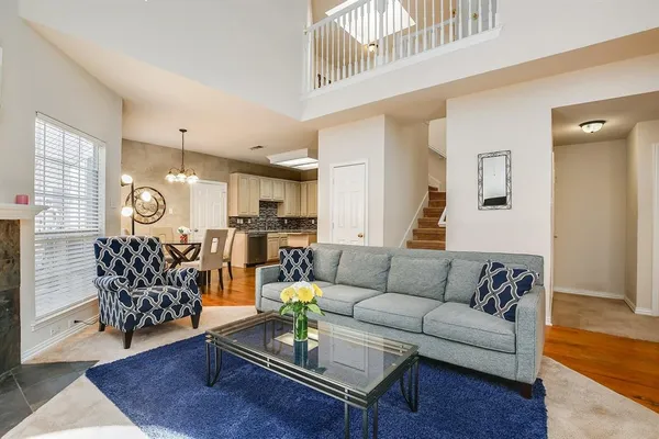 a living room with furniture hard wood floor and a chandelier
