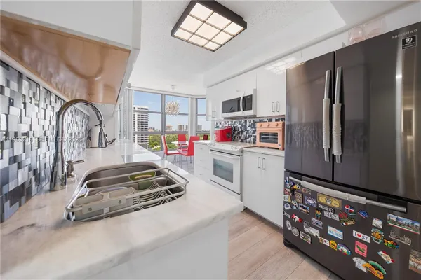 a kitchen with stainless steel appliances a sink and a refrigerator