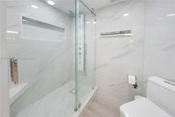 a bathroom with a toilet and a shower