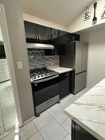 a kitchen with granite countertop a refrigerator and a stove