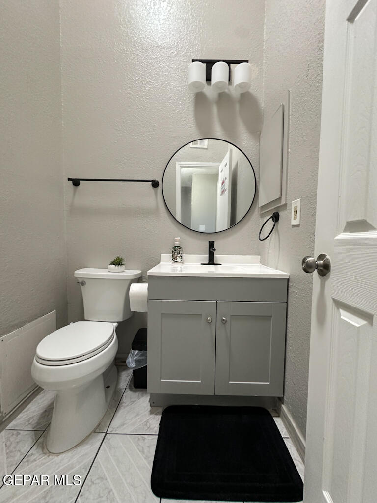 824 Destello Road El Paso, TX 79907 - Photo 9 of 16 a bathroom with a toilet a sink and mirror