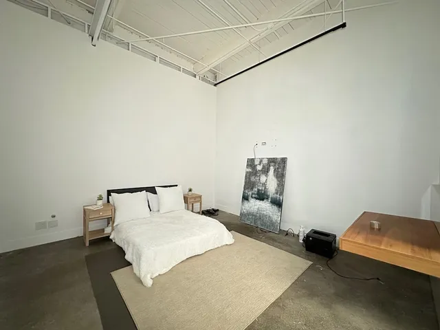 a bedroom with a bed and a lamp on the dresser