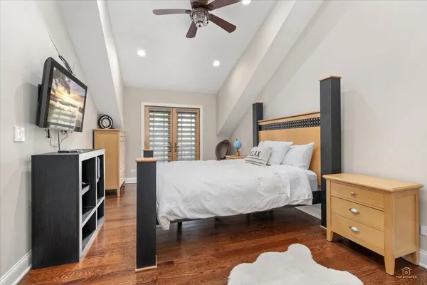 a bedroom with a bed and a flat tv screen on dresser