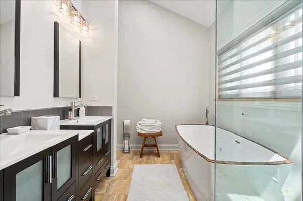 a bathroom with a tub sink and mirror