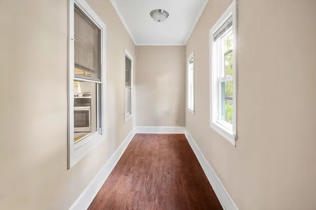 a view of a hallway with wooden floor and windows