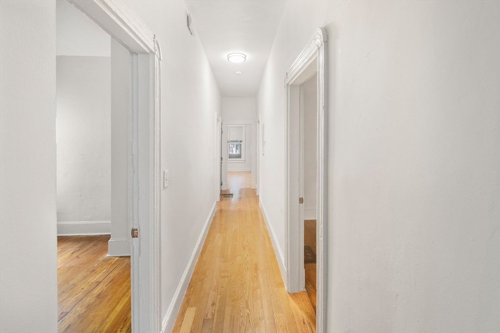 53 Copeland Street, Unit 2 Boston, MA 02119 - Photo 3 of 15 a view of a hallway with wooden floor and staircase