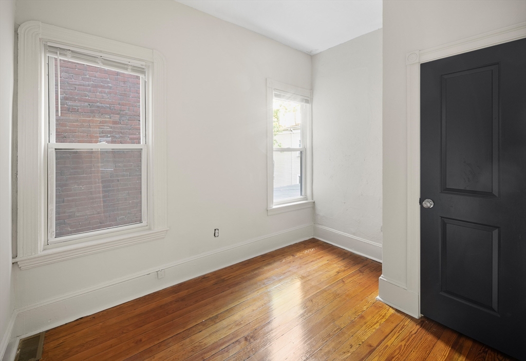 53 Copeland Street, Unit 2 Boston, MA 02119 - Photo 5 of 15 a view of empty room with wooden floor and fan