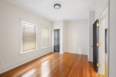 a view of a big room with wooden floor and windows
