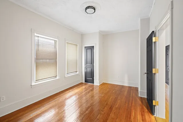 a view of a big room with wooden floor and windows
