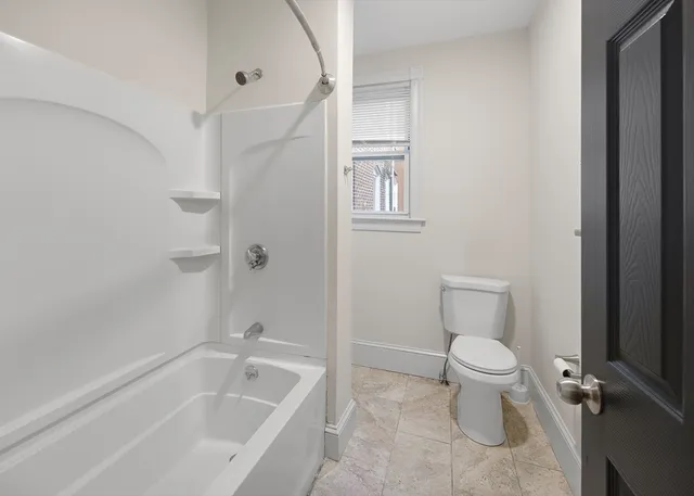 a white toilet sitting next to a bath tub