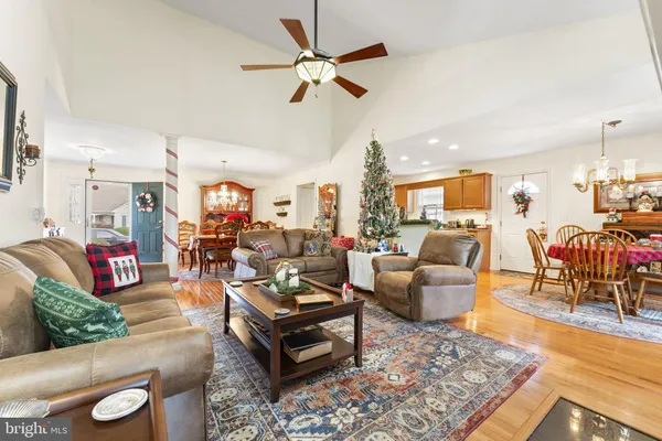 a living room with furniture kitchen view and a chandelier