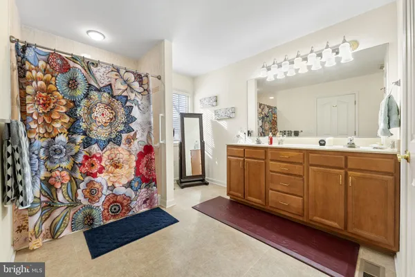a spacious bathroom with a double vanity sink mirror and shower