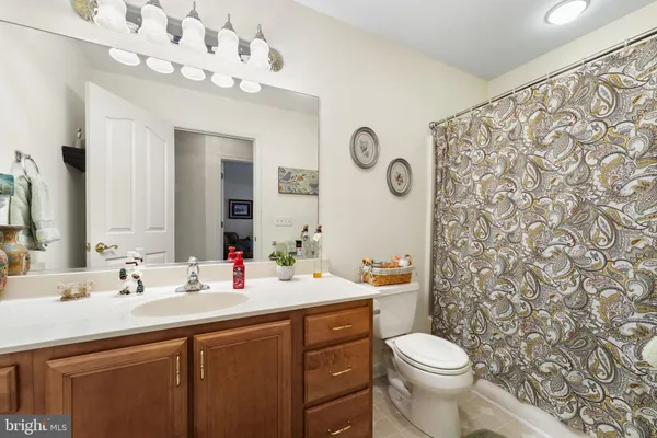 a bathroom with a sink vanity mirror and toilet