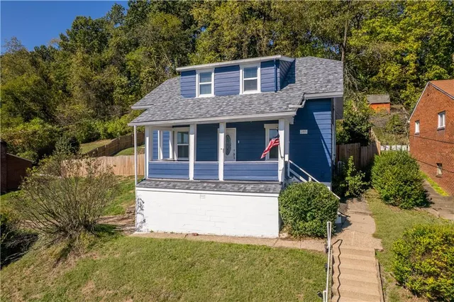 a view of a house with a yard and potted plants