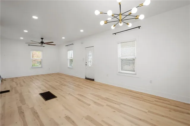 a view of empty room with window and ceiling fan