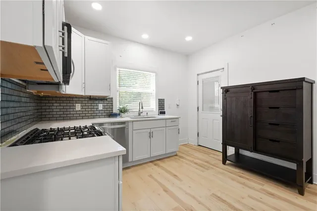 a kitchen with a refrigerator a stove a sink and cabinets