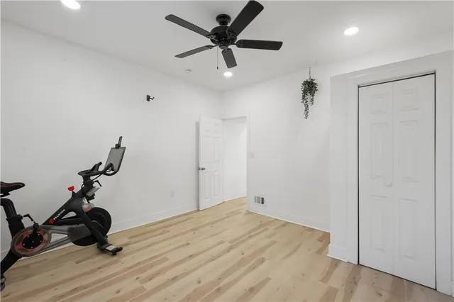 a view of a room with gym equipment and a ceiling fan