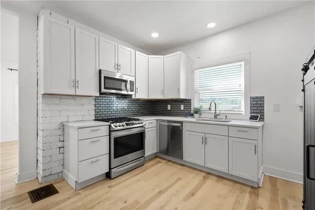 a kitchen with granite countertop white cabinets and appliances