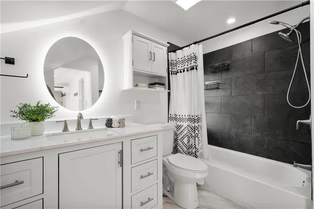 a bathroom with a double vanity sink toilet mirror and shower