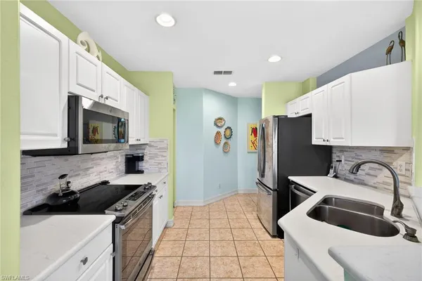 a open kitchen with stainless steel appliances granite countertop a sink and a refrigerator