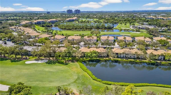 an aerial view of residential houses with outdoor space and lake view