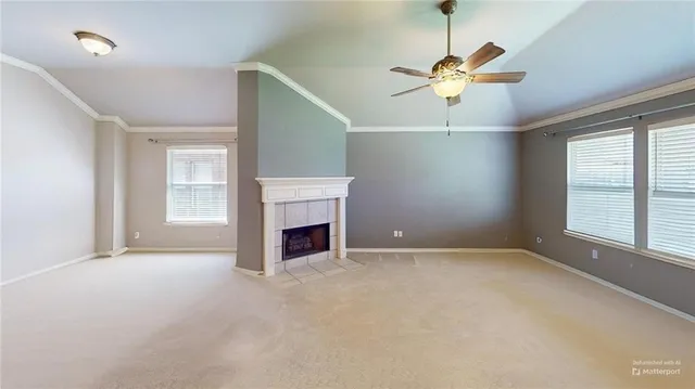 an empty room with windows and ceiling fan